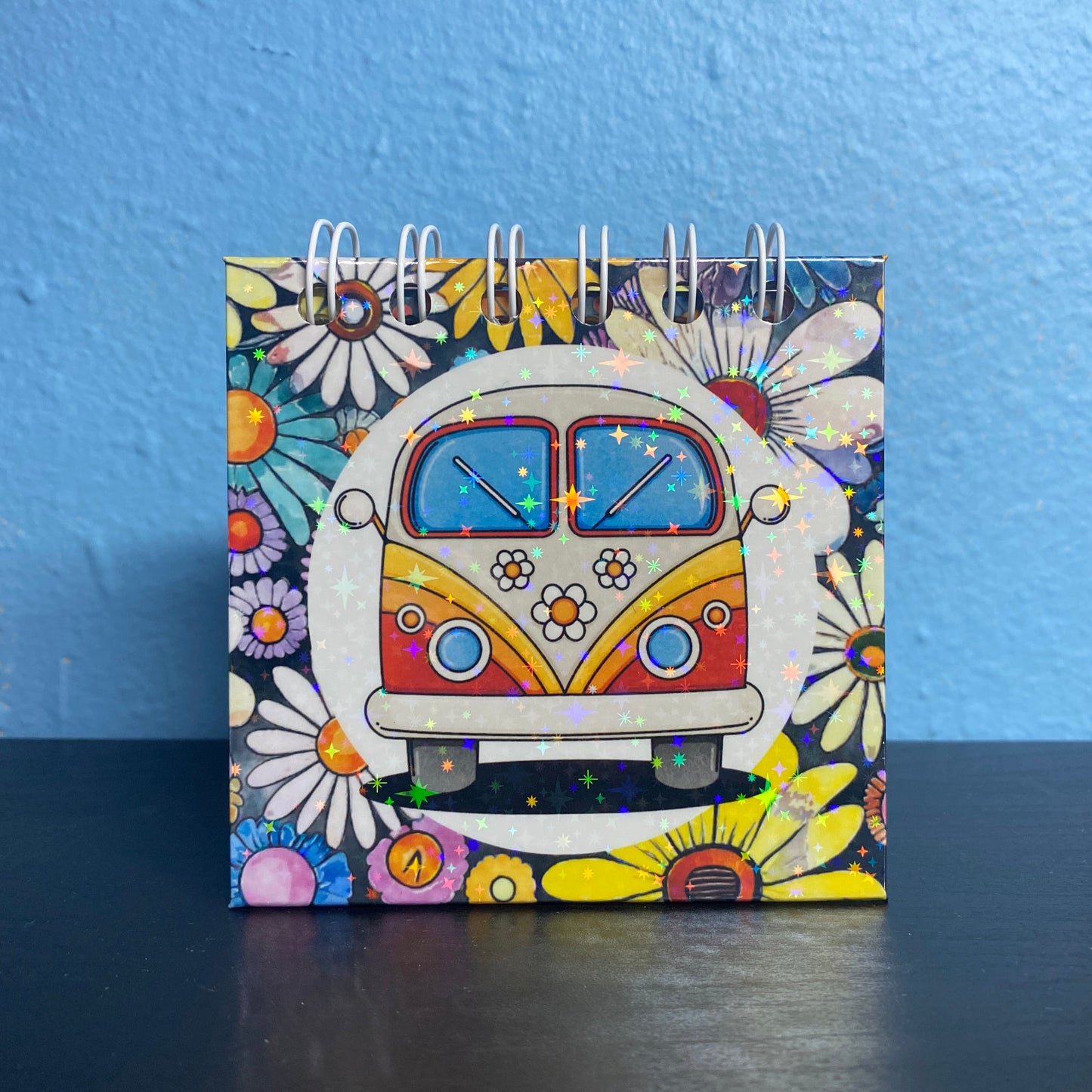 Notebook with a colorful design of a van and flowers on a blue background