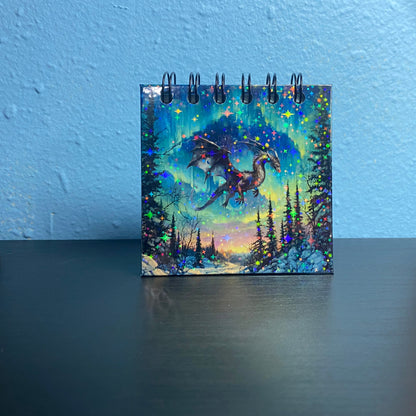 Notebook with a dragon illustration on a blue wall background