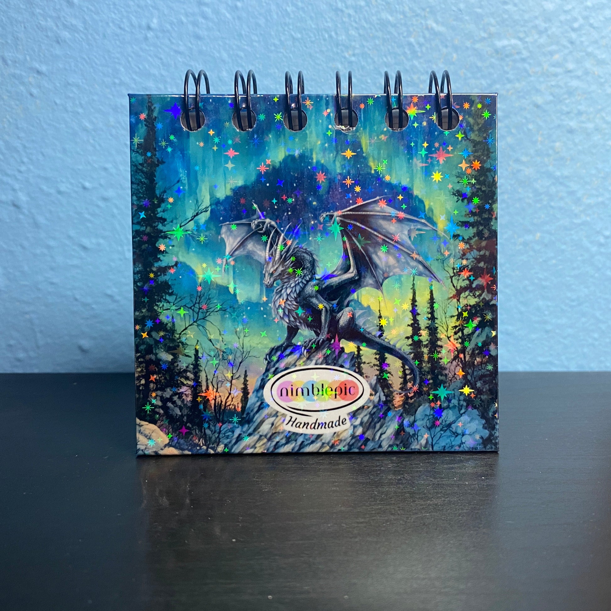 Small notebook with dragon illustration on a blue background