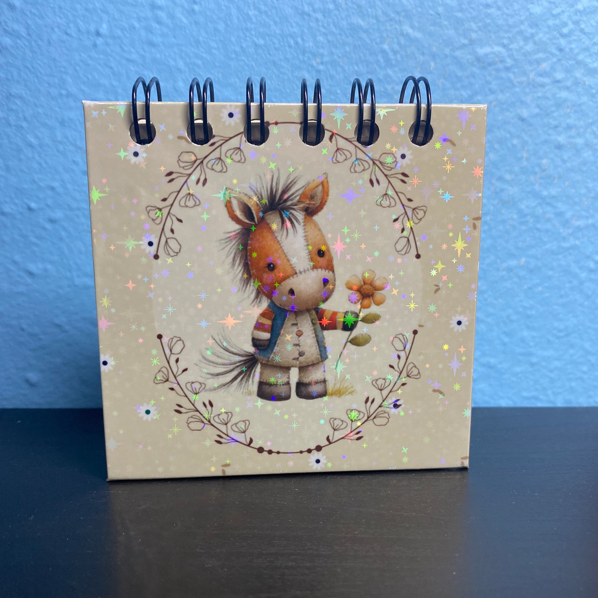 Small notebook with a cute animal illustration on a blue surface