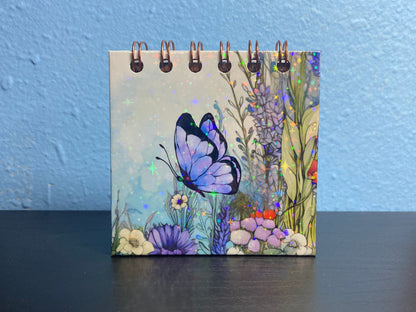 Small notebook with a colorful butterfly design on a blue background