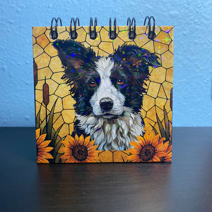 Small notebook with a dog illustration on a yellow background with sunflowers