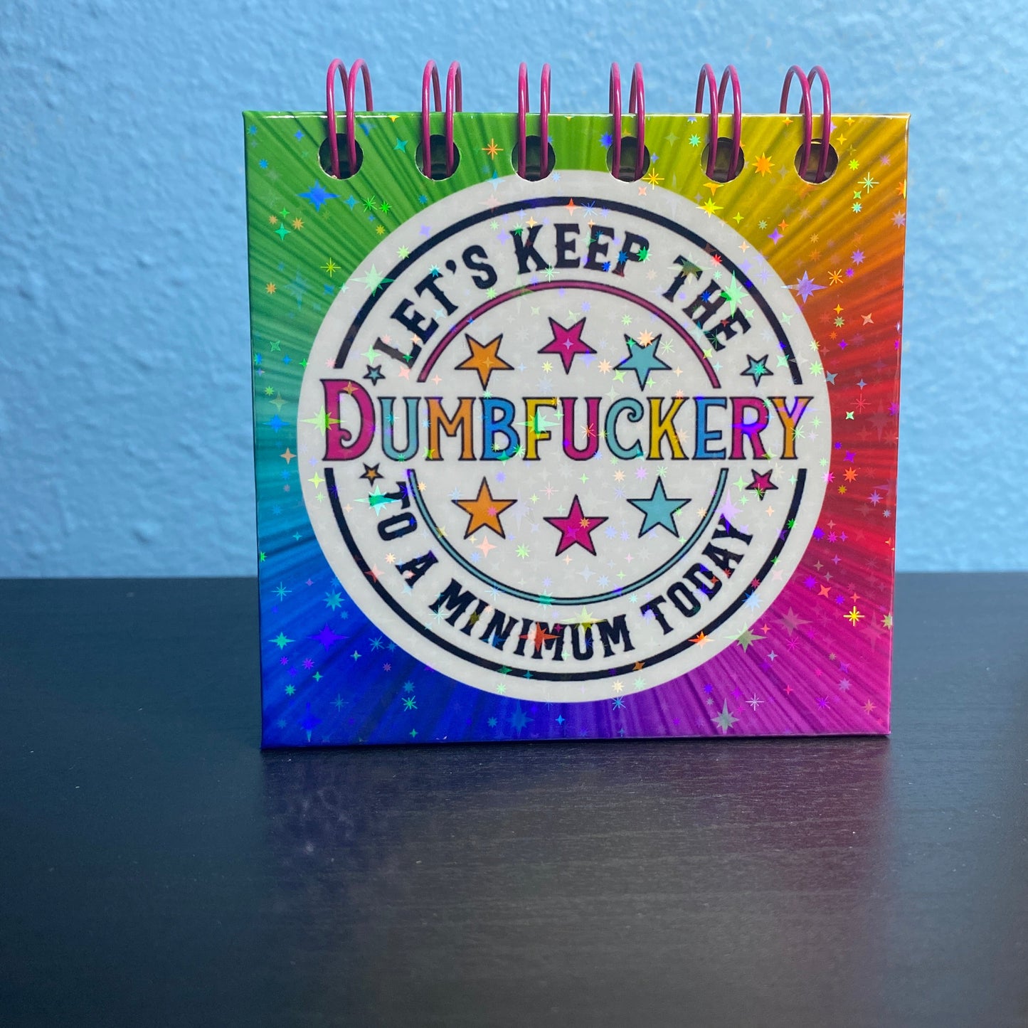 Small notebook with colorful design and text on a blue surface